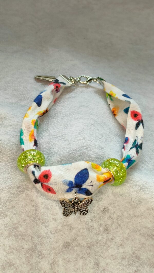 Bracelet en tissu blanc agrémenté de motifs fleuris et de papillons